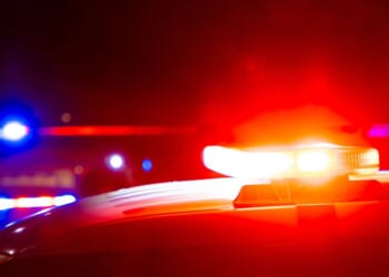 Red and blue police lights on a car at a crime scene at night with copy space.