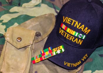 A Vietnam veteran’s hat is pictured on a camouflage fabric.