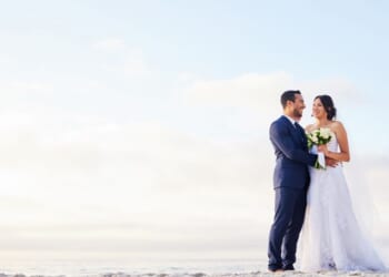 A young couple on the beach on their wedding day.