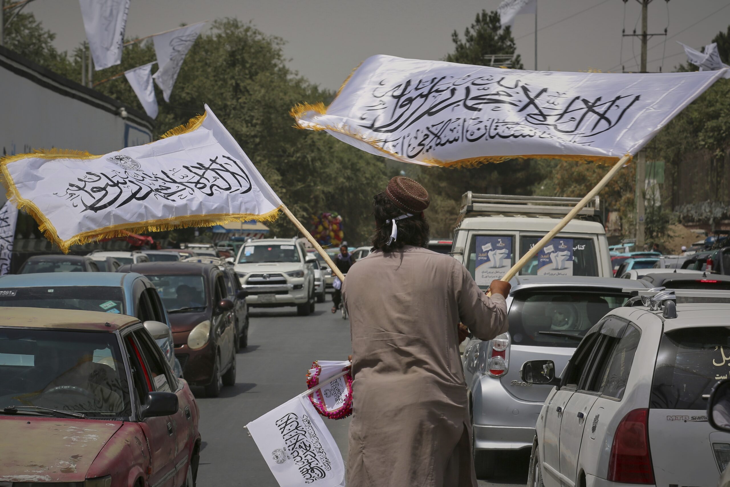 A man waves Taliban flags for sale on Thursday, ahead of celebrations marking the fourth anniversary of the U.S. withdrawal from Afghanistan and the start of Taliban rule in Kabul.
