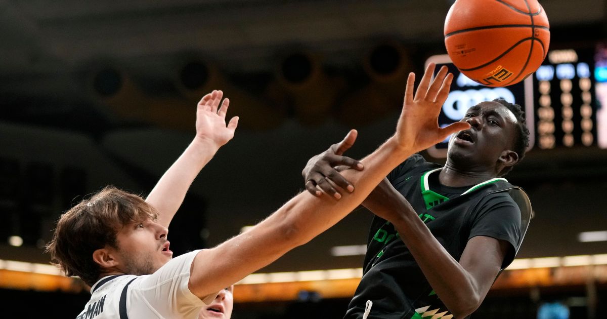 College basketball forward Deng Mayar attempts to block a player from scoring in Iowa City, Iowa, on Nov. 7, 2023.
