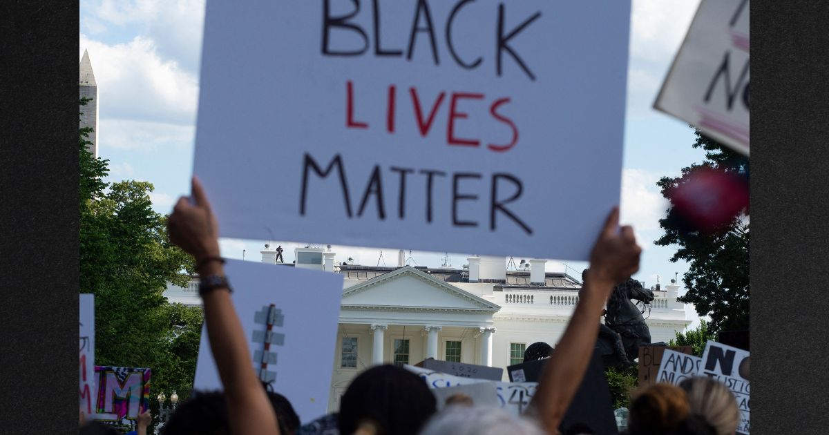 Demonstrators protesting the death of George Floyd hold up placards up near the White House on May 31, 2020 in Washington, D.C.