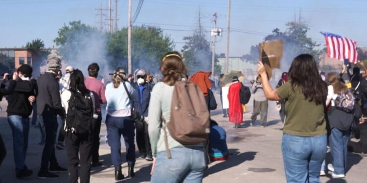 Federal agents fire chemicals as protesters attempt to block car at immigration site outside Chicago