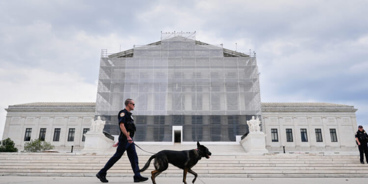 A Capitol Police officer walks a dog outside of the Supreme Court on Sept. 24, 2025, in Washington, DC.
