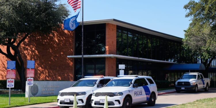 Homeland Security personnel sit in their vehicles in front of the U.S. Immigration and Customs Enforcement office in Dallas, Texas, on Thursday.