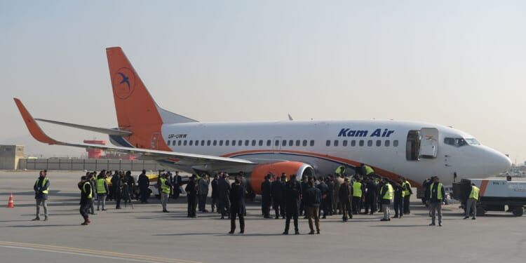 Kam Air employees gather by an airplane at a ceremony for Ukrainian employees of the Afghan airline at Kabul International Airport on Jan. 24, 2018, following their deaths in a Taliban attack on the Intercontinental Hotel.