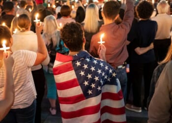 An attendee wears a U.S. flag during a candlelight vigil for Turning Point USA founder Charlie Kirk on Sept. 10, 2025, in Seattle, Washington.