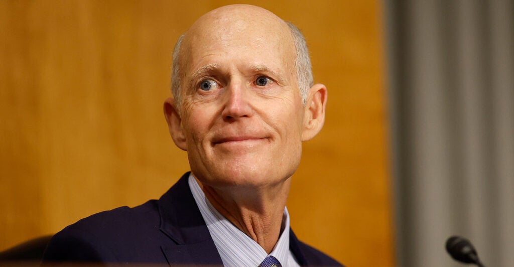 Senator Rick Scott sits in a committee room in the capitol.