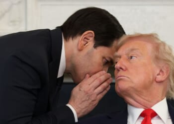 Secretary of State Marco Rubio interrupts a roundtable discussion to whisper to President Donald Trump at the White House Thursday.
