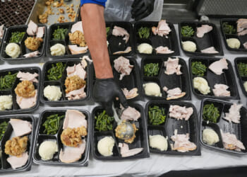 A volunteer prepares meals Thursday at the Philabundance Community Kitchen in Philadelphia.