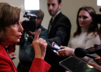 Rep. Nancy Pelosi, a Democrat from California, talks to reporters in the hallway outside of a House Democratic caucus meeting at the U.S. Capitol Visitors Center Wednesday in Washington, D.C.