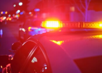 A police car displays its flashing lights on the road.