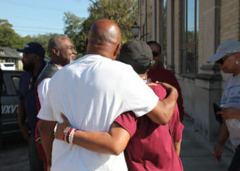 Friends and family of victims of a homecoming shooting embrace in downtown Leland, Mississippi, on Saturday.