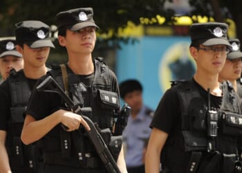 Armed Chinese police patrol a street in Urumqi, China in the Xinjiang region on July 3, 2010.