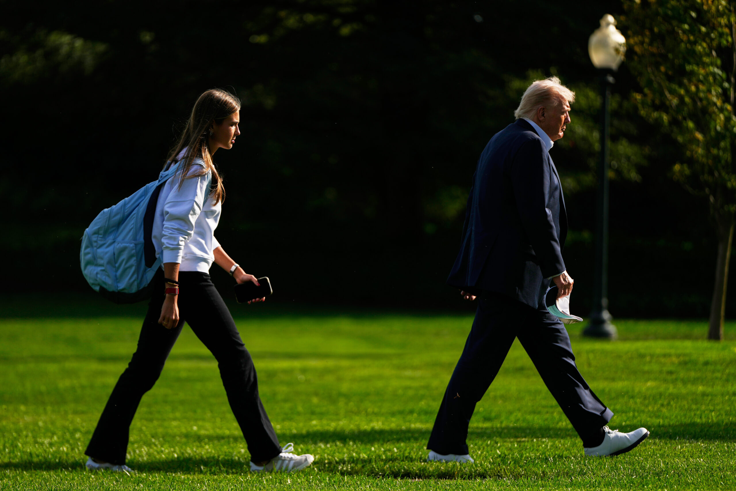 President Donald Trump, right, arrives with his granddaughter Kai Trump at the White House, Sept. 26.