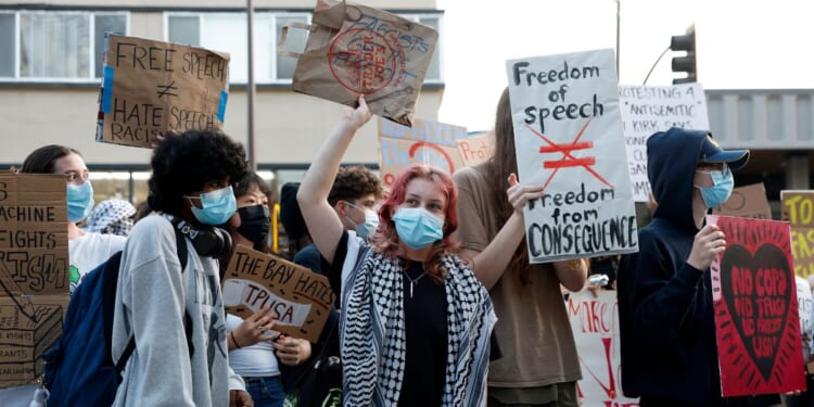 Protesters hold signs as they demonstrate outside of a Turning Point USA event at the University of California, Berkeley, on Nov. 10, 2025, in Berkeley, California.