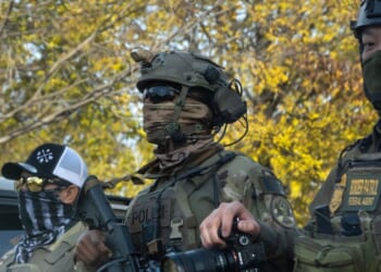 Federal agents searching for illegal aliens in Chicago, Illinois, as a part of Operation Midway Blitz pause to regroup in a park on Thursday.