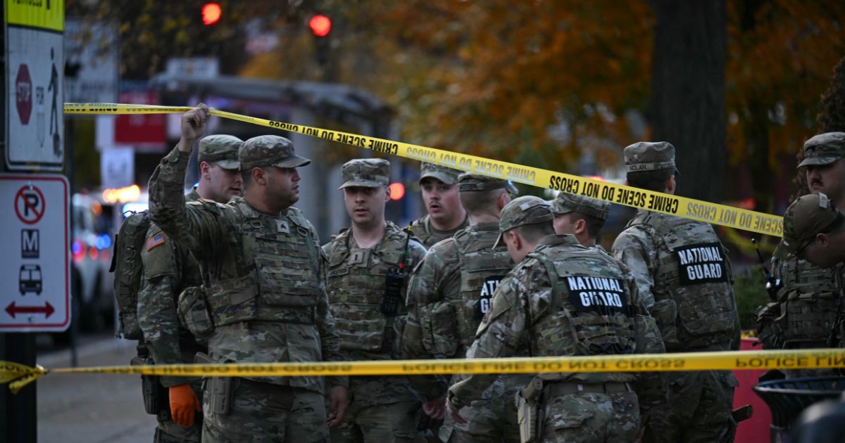 National Guard soldiers stand behind the crime scene tape at a corner in downtown Washington, D.C., on Nov. 26, 2025.