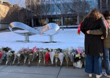 Senior Zoe Kass and her boyfriend leave flowers Dec. 16 at the engineering building at Brown University in Providence, Rhode Island. They fled the building Dec. 13 when a shooter opened fire during a finals study session.