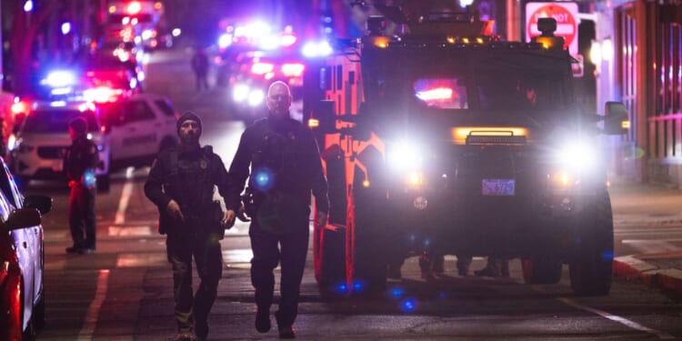 Police officers remain on the scene of a shooting that killed two and wounded at least eight at Brown University on Dec. 13, 2025, in Providence, Rhode Island.