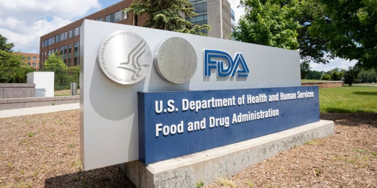 The FDA logo displayed on a sign outside the headquarters of the Food and Drug Administration of the Department of Health and Human Services (HHS).