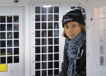 Greta Thunberg is arrested and sits in the back of a police van outside the offices of Aspen Insurance on Dec. 23, 2025, in London, England.