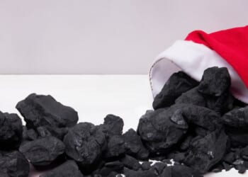A pile of coal emerges from a Santa Claus hat.