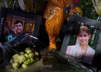 Framed photos of mass shooting victims Mukhammad Aziz Amurzokov and Ella Cook are seen Monday at a makeshift memorial near Brown University in Providence, Rhode Island.