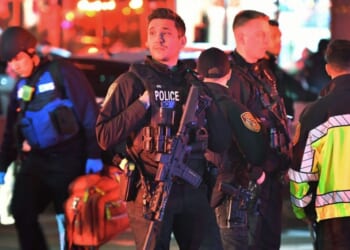 Law enforcement officials carrying weapons gather near Brown University in Providence, Rhode Island.