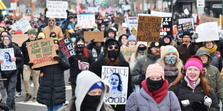 Protesters hold signs as they march from Powderhorn Park in Minneapolis against Immigration and Customs Enforcement and the fatal shooting of Renee Good by an ICE agent, calling on federal authorities to leave the city, in Minneapolis, Minnesota, on Jan. 10, 2026.