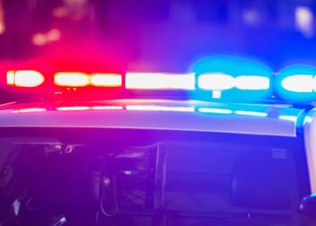 The roof of a police car at night as its lights flash red and blue.