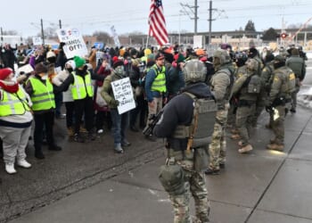 Federal agents stand watch as protestors gather outside the Bishop Henry Whipple Federal Building in Saint Paul, Minnesota, on Jan. 8, 2026.