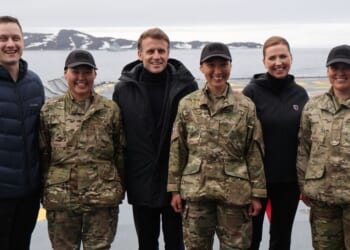 French President Emmanuel Macron, Danish Prime Minister Mette Frederiksen, and Prime Minister of Greenland Jens-Frederik Nielsen pose with military personnel on board the Danish frigate F363 Niels Juel in Nuuk, Greenland, on June 15, 2025.