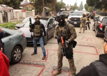 Border Patrol agents and other law enforcement clear the way for an authorized car to pass while investigating a shooting involving a federal agent on Wednesday morning in Willowbrook, California, on Jan. 21, 2026.
