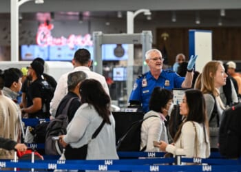 A TSA agent works at a security checkpoint as travelers wait in line at George Bush Intercontinental Airport in Houston, Texas, on Nov. 7, 2025.