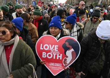 People hold signs at a pro-life March for Life rally in Washington, DC, on Jan. 23, 2026.