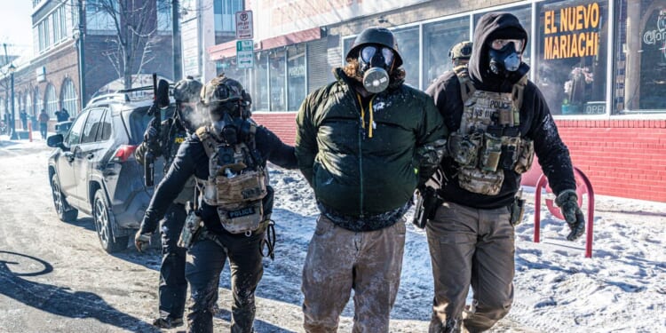 Federal agents detain a protester along a commercial street during clashes following the fatal shooting of a demonstrator earlier in the day, on Jan. 24, 2026, in Minneapolis, Minnesota.