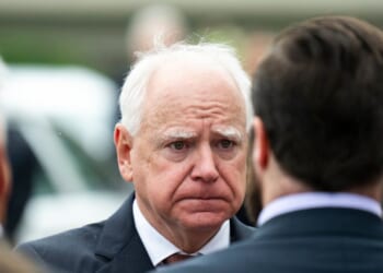 Minnesota Governor Tim Walz presents a Minnesota flag to a family after a funeral ceremony for DFL Rep. Melissa Hortman in Minneapolis, Minnesota, on June 28, 2025.