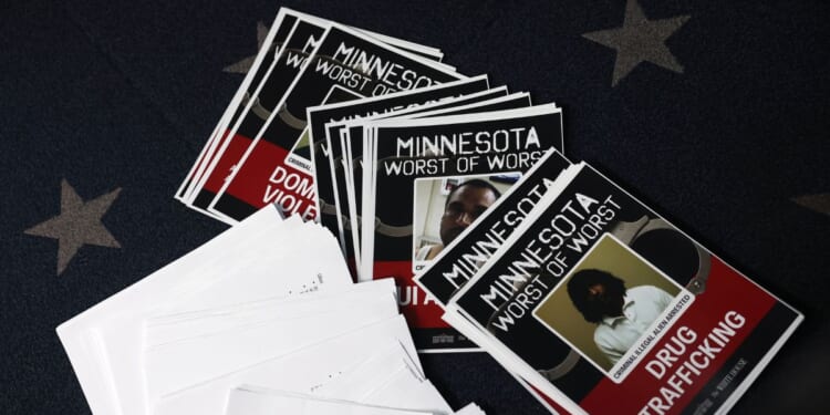 Documents with mugshots labeled "Minnesota Worst of the Worst" are scattered as President Donald Trump speaks during a news briefing in the James S. Brady Press Briefing Room of the White House on Jan. 20, 2026, in Washington, D.C.