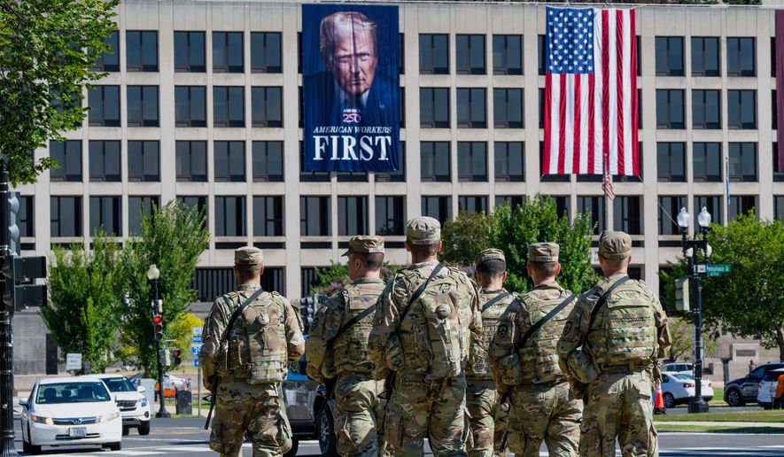 Armed National Guard soldiers from West Virginia patrol the Mall near the Labor Department in Washington, where a poster of President Donald Trump is displayed, Aug. 26, 2025. (AP Photo/J. Scott Applewhite) **FILE**