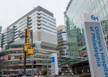 People walking on street in front of buildings of Hospital of the University of Pennsylvania and the Children's Hospital of Philadelphia.