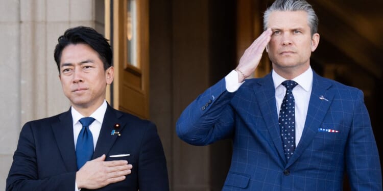 Defense Secretary Pete Hegseth and Japanese Defense Minister Shinjiro Koizumi, left, stand for the national anthems Thursday as Koizumi arrives for meetings at the Pentagon in Washington, D.C.