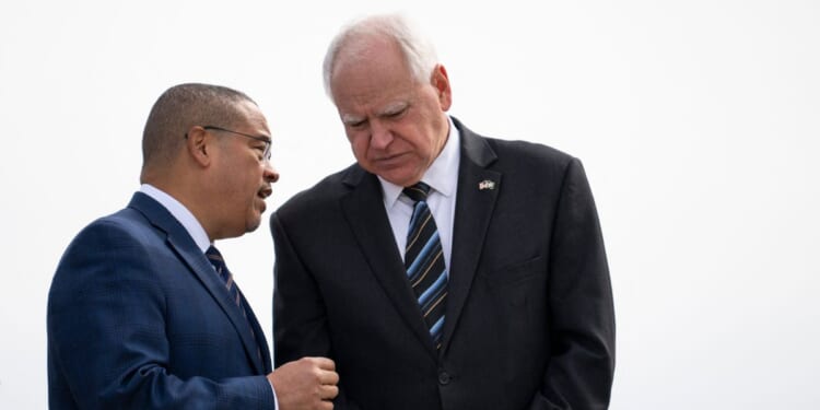 Minnesota Attorney General Keith Ellison and Minnesota Governor Tim Walz await the arrival of Vice President Kamala Harris at the Minneapolis-St. Paul International Airport in Saint Paul, Minnesota, on March 14, 2024.