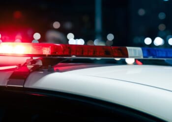 A close up view of flashing police lights on top of a car at night.