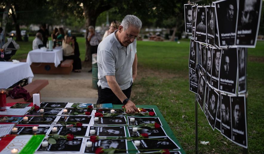 Geev Lameh places a candle by photos described as Iranian protesters killed in January, during a community gathering ahead of the Nowruz holiday in the Encino neighborhood of Los Angeles, March 17, 2026. (AP Photo/Jae C. Hong)