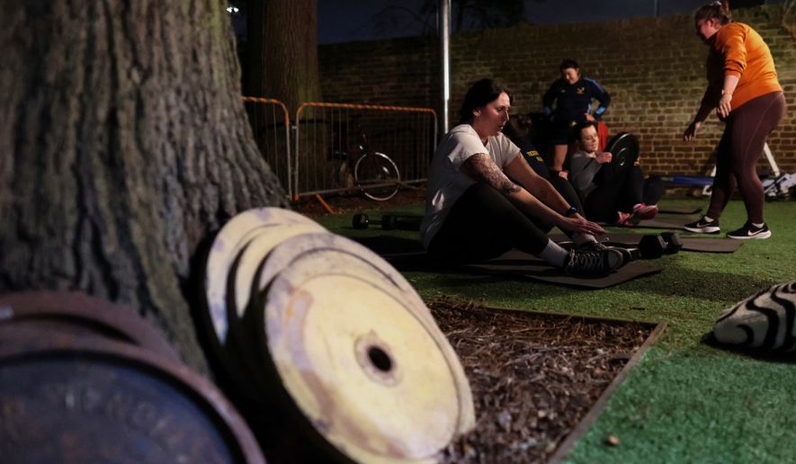Chloe Spriggs, left, takes a moment as members of Teddington women's rugby team use weights as they train at the club house in Bushy Park in London, Thursday, Jan. 16, 2025. (AP Photo/Charlotte Coney,File)b