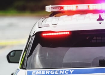 A stock photo of a police car with lights activated.