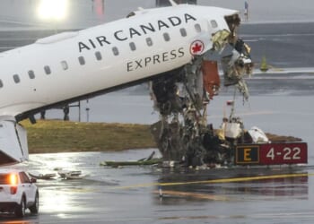An Air Canada Express CRJ-900 sits on the runway Monday after colliding with a Port Authority fire truck Sunday night at LaGuardia Airport in New York.