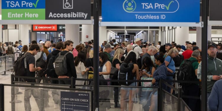Travelers wait in a TSA pre-check security line at Miami International Airport in Miami, Florida. Travelers across the country are enduring long airport security lines as a partial federal government shutdown affects Transportation Security Administration officers, who recently received $0 paychecks.