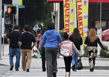 A student wearing a backpack crosses a street near Van Nuys Elementary School in the working class neighborhood Van Nuys of Los Angeles, California, on June 9, 2025.